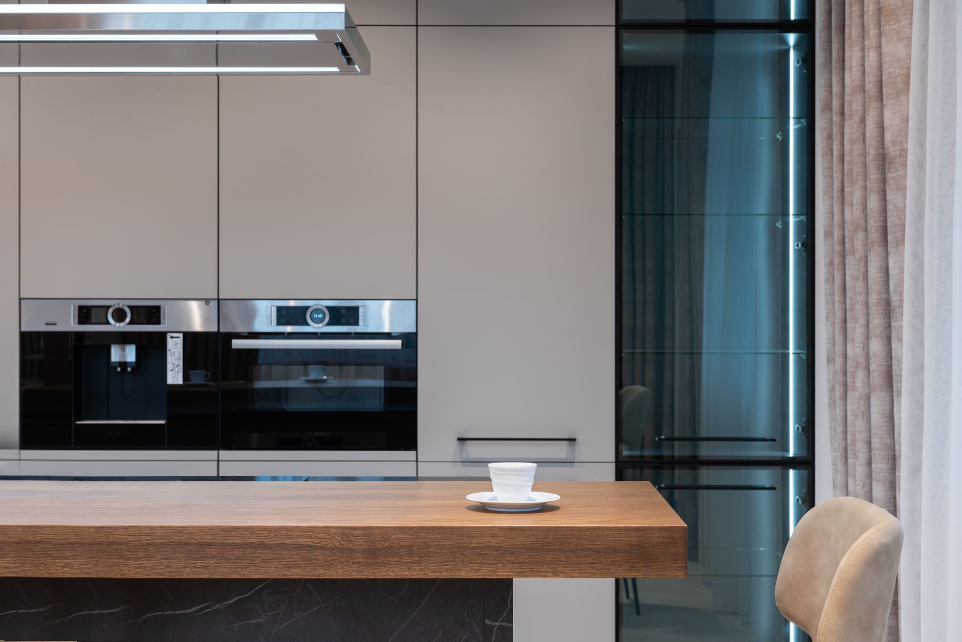 Modern room with kitchenware and counter with coffee cup near chairs and curtains with cabinet and oven in Scottsdale, AZ